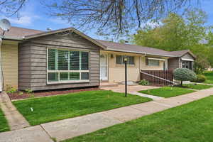 Ranch-style townhouse featuring brick siding, a front lawn, and a shingled roof