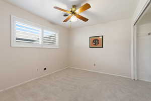 Unfurnished bedroom with carpet floors, a closet, and ceiling fan