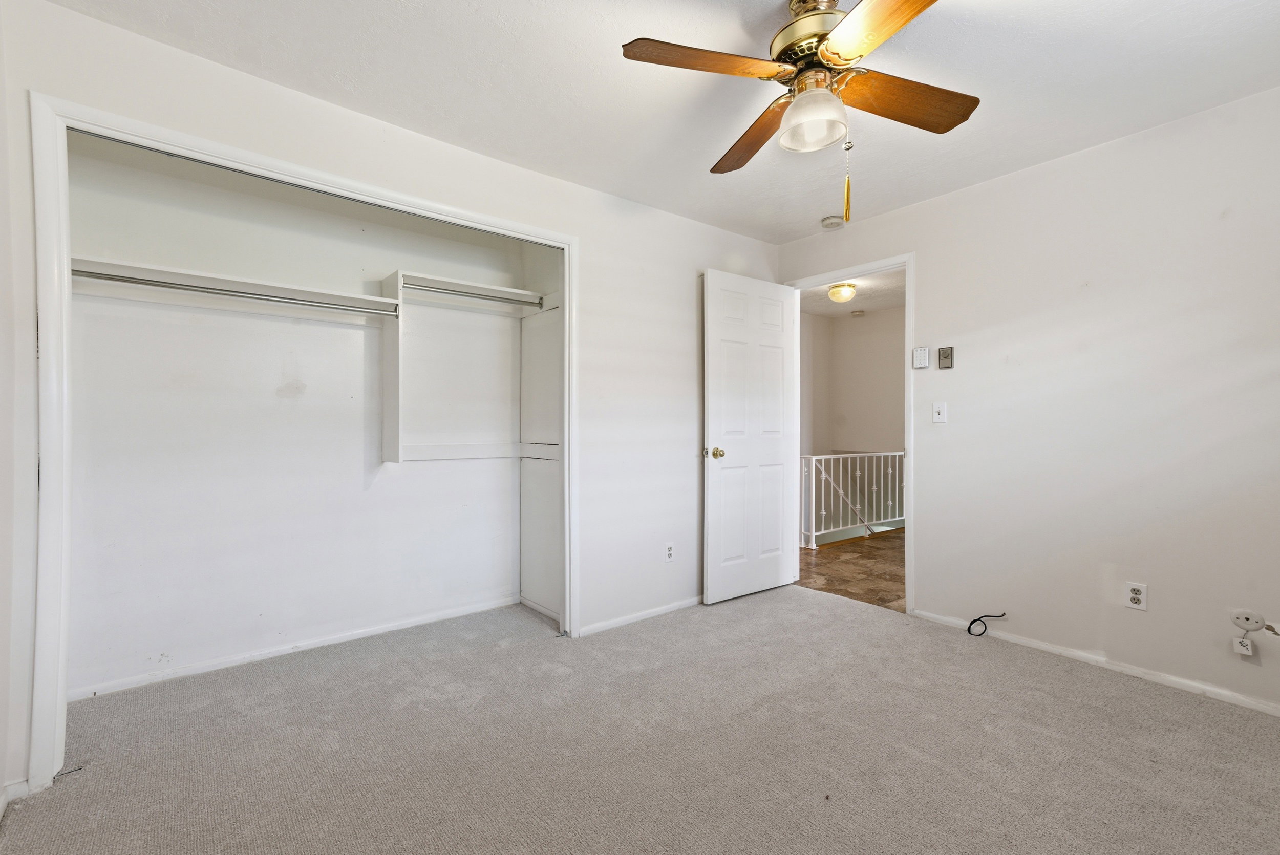 Unfurnished bedroom featuring carpet floors, ceiling fan, and a closet