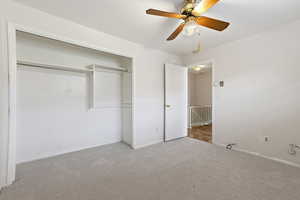 Unfurnished bedroom featuring carpet floors, ceiling fan, and a closet