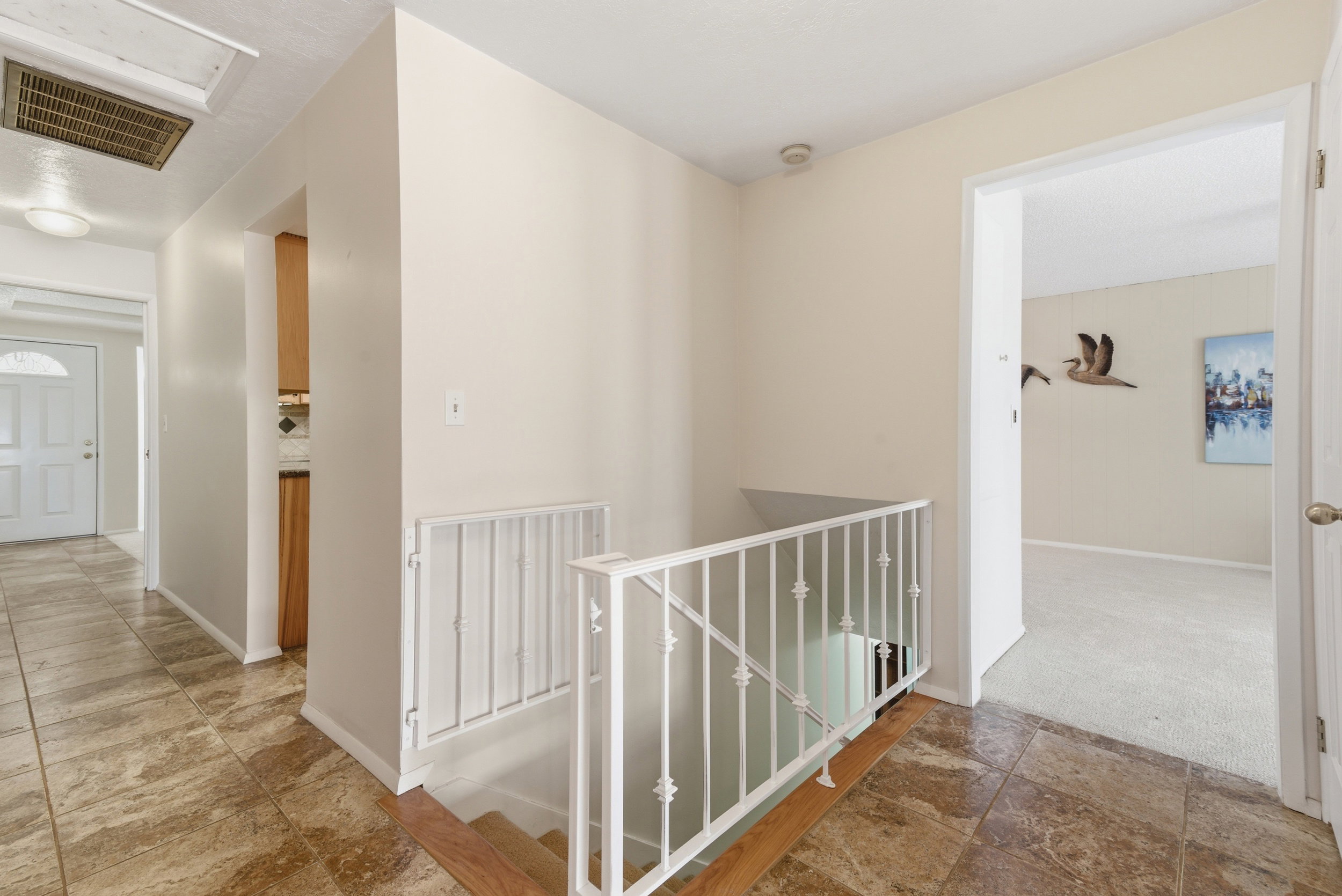 Hallway featuring stone finish floors and an upstairs landing