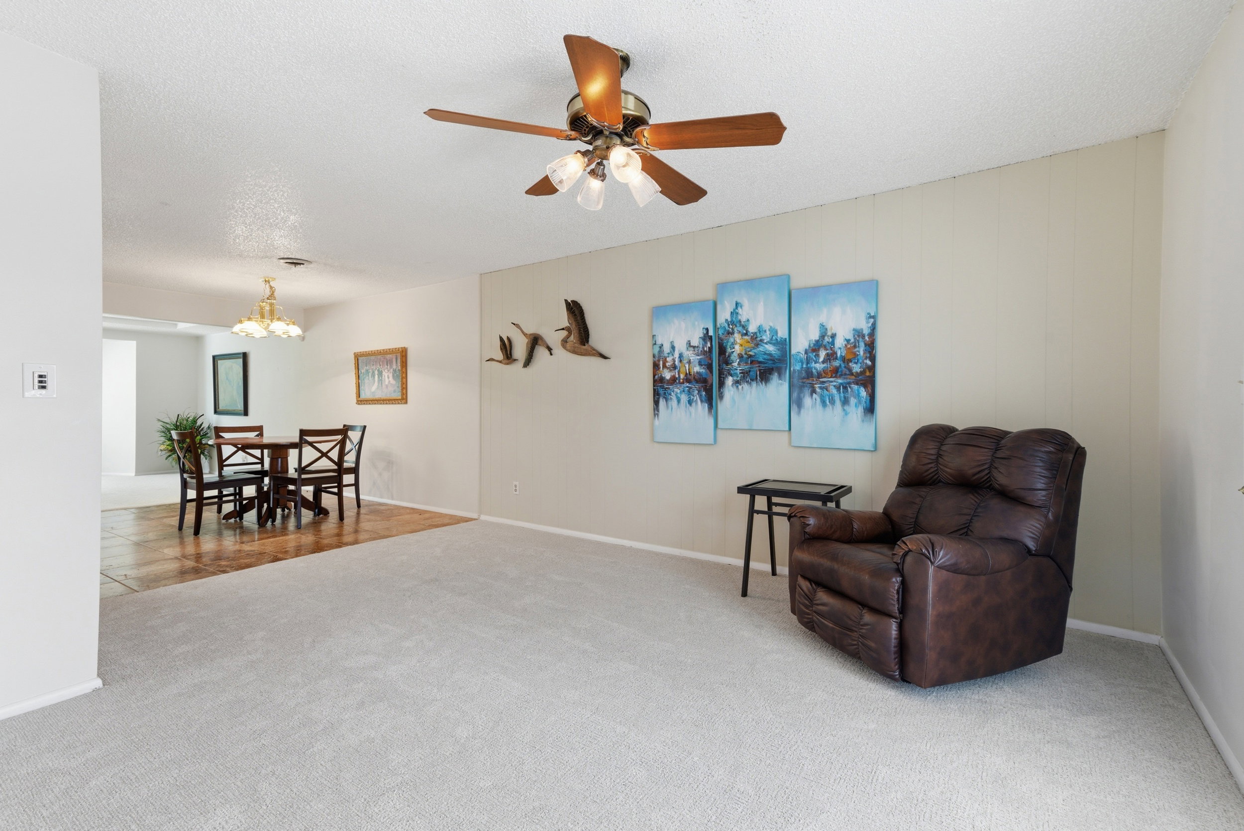 Sitting room with light colored carpet, a ceiling fan, a textured ceiling, and hanging lights