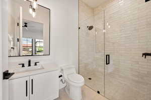 Bathroom with vanity, a stall shower, light tile patterned flooring, and a ceiling fan