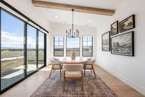 Dining room with beamed ceiling, light wood-style flooring, and suspended lighting