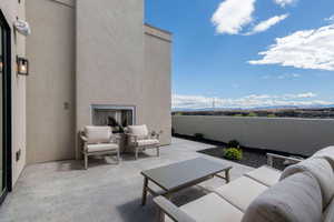 View of patio with an outdoor living space with a fireplace