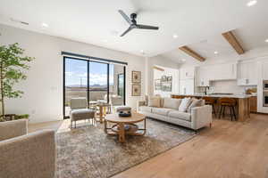 Living area featuring light wood-type flooring, ceiling fan, beamed ceiling, recessed lighting, and a mountain view