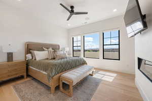 Bedroom with light wood-type flooring, ceiling fan, and recessed lighting