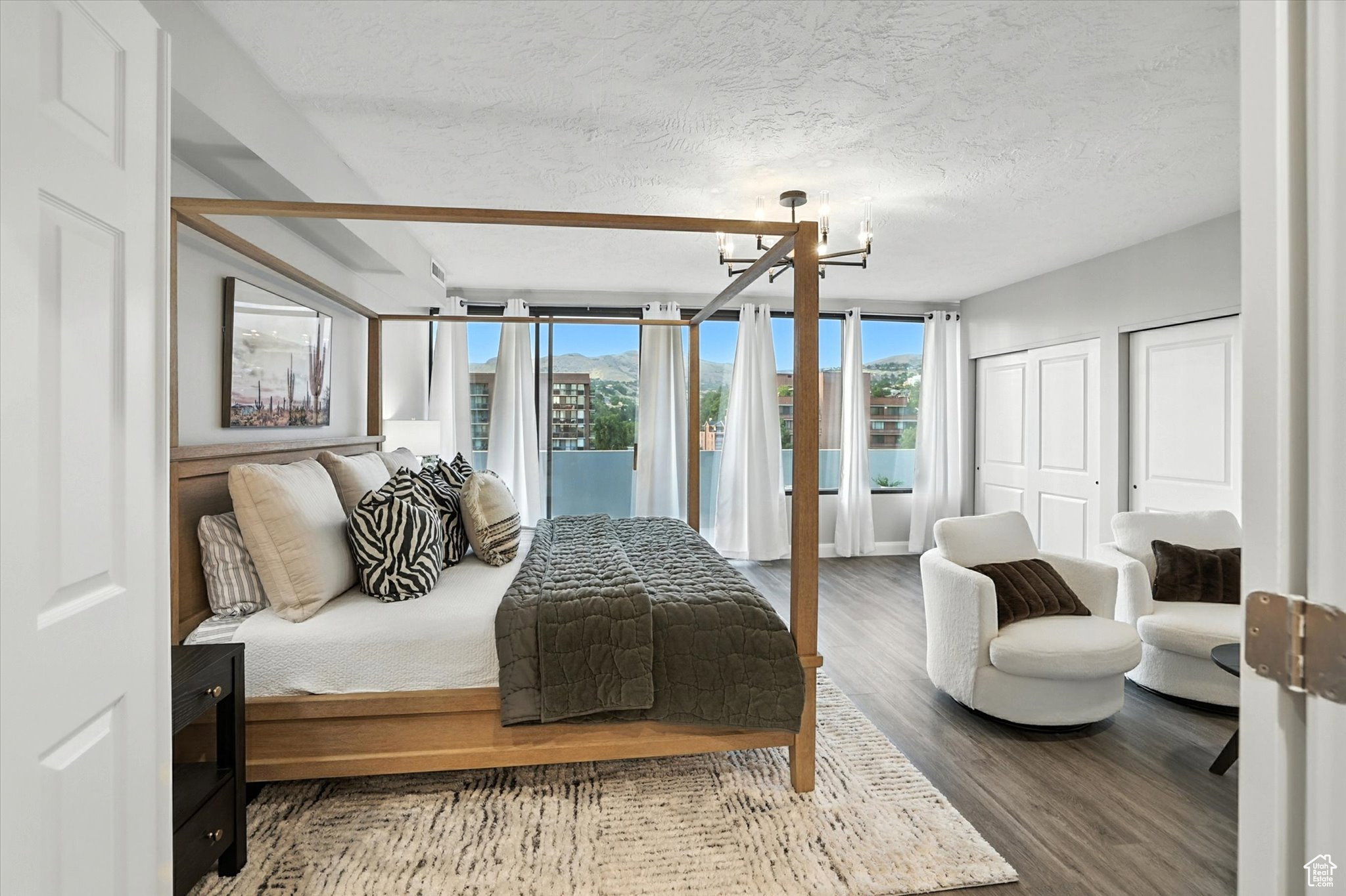 Top floor bedroom suite featuring a chandelier, multiple closets, and access to the roof top deck