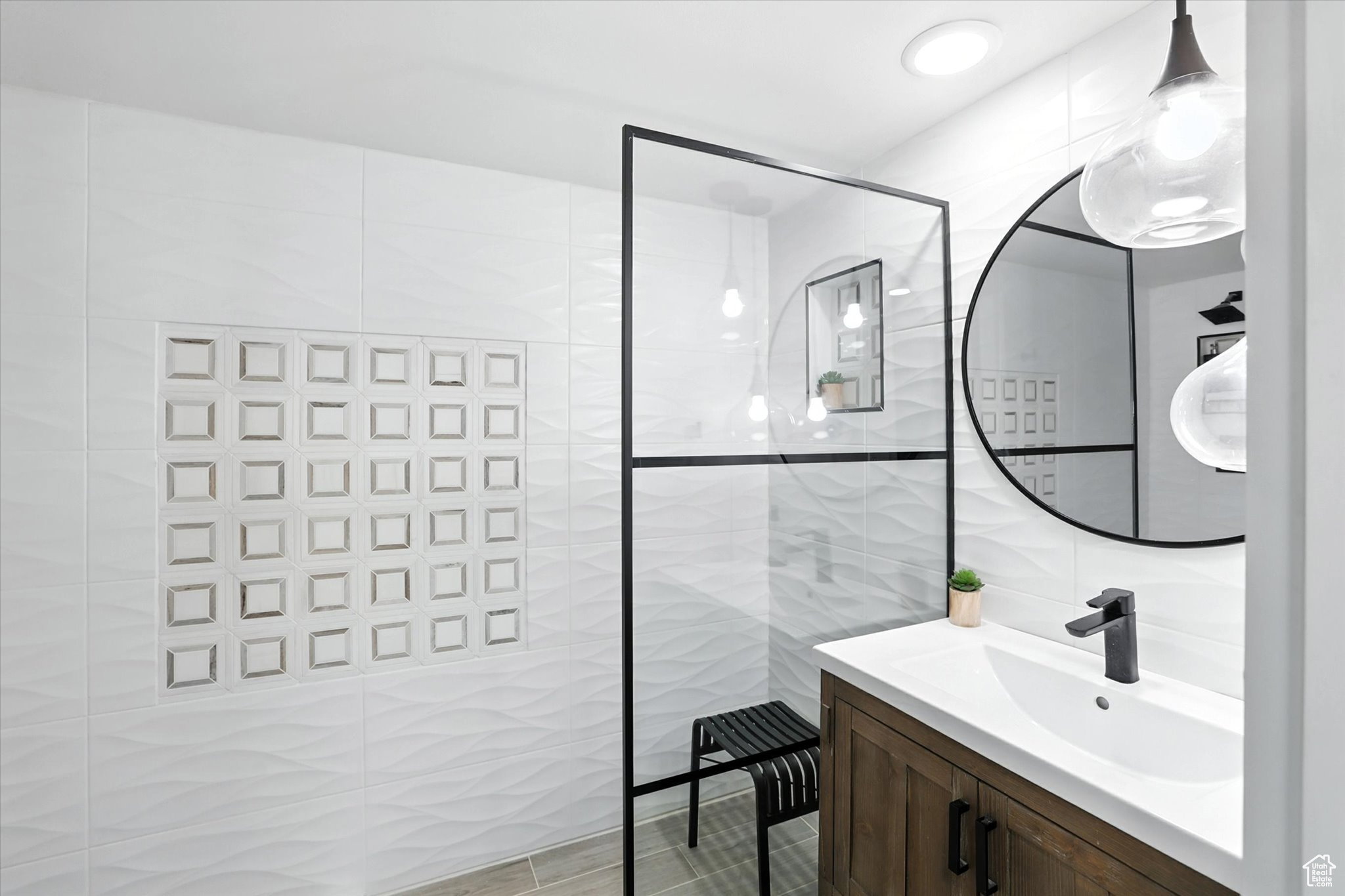 Bathroom suite with tile walls, vanity, and a walk in shower