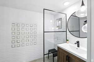 Bathroom suite with tile walls, vanity, and a walk in shower