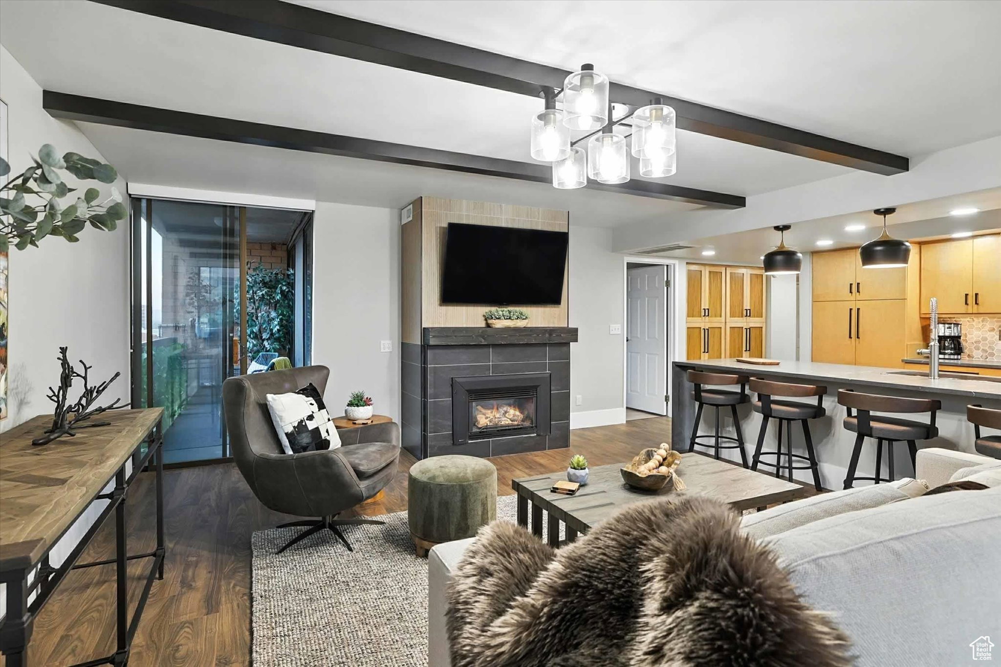 Living room with beamed ceiling, a gas fireplace, and recessed lighting