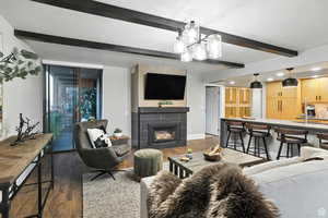 Living room with beamed ceiling, a gas fireplace, and recessed lighting