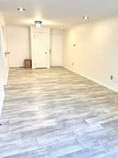 Unfurnished room with ornamental molding and light wood-style floors