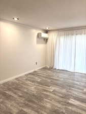 Empty room with crown molding, dark wood-style floors, and recessed lighting