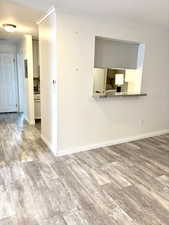 Unfurnished room with crown molding and light wood-style flooring