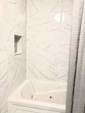 Bathroom with a combined bath / shower with jetted tub