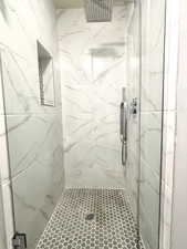 Bathroom featuring a marble finish shower