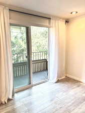 Entryway with wood-type flooring and crown molding