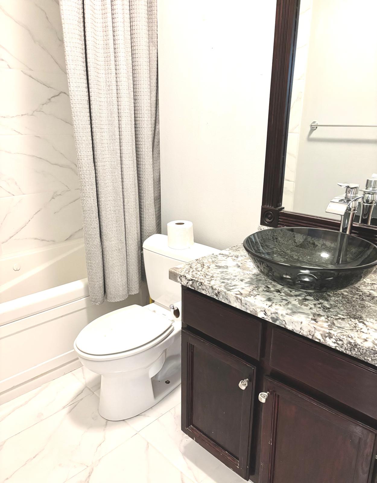 Bathroom with vanity, light marble finish flooring, and shower / tub combo with curtain