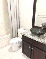 Bathroom with vanity, light marble finish flooring, and shower / tub combo with curtain