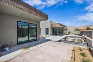 Rear view of property featuring stucco siding, a patio area, a fenced backyard, and a mountain view