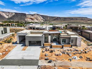 Contemporary house with a mountain view, driveway, stucco siding, and a residential view