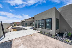 Back of property featuring stucco siding, a fenced backyard, and a patio