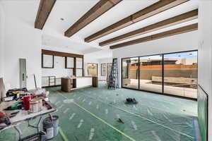 Living area featuring beam ceiling and healthy amount of natural light