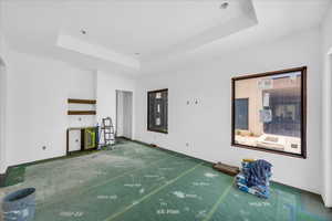 Unfurnished living room with a tray ceiling