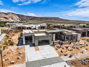 Contemporary home featuring a mountain view, a residential view, concrete driveway, stucco siding, and an attached garage