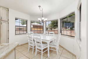 Dining area featuring a chandelier and light tile patterned flooring