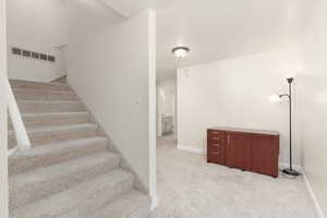 Stairway with carpet flooring and baseboards