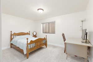 Bedroom featuring light colored carpet and baseboards