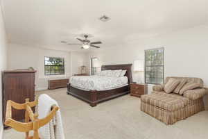 Bedroom featuring light carpet, crown molding, and a ceiling fan