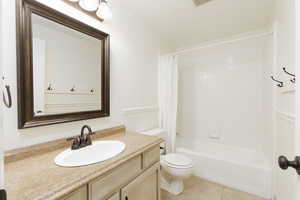 Bathroom featuring vanity, shower / tub combo with curtain, and light tile patterned floors
