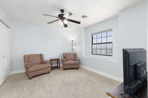 Sitting room featuring light carpet and a ceiling fan