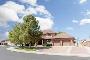 View of front facade with a garage, a residential view, a tile roof, and concrete driveway
