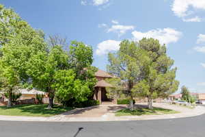 Obstructed view of property featuring brick siding and a front yard