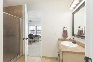 Full bath with vanity, a stall shower, light tile patterned floors, and ceiling fan
