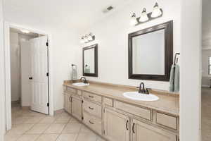 Full bathroom with double vanity, ornamental molding, and light tile patterned floors