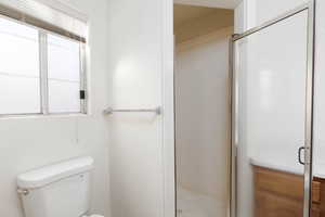 Bathroom featuring a stall shower and toilet