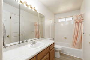 Bathroom featuring vanity, shower / bath combo, and light wood-style flooring
