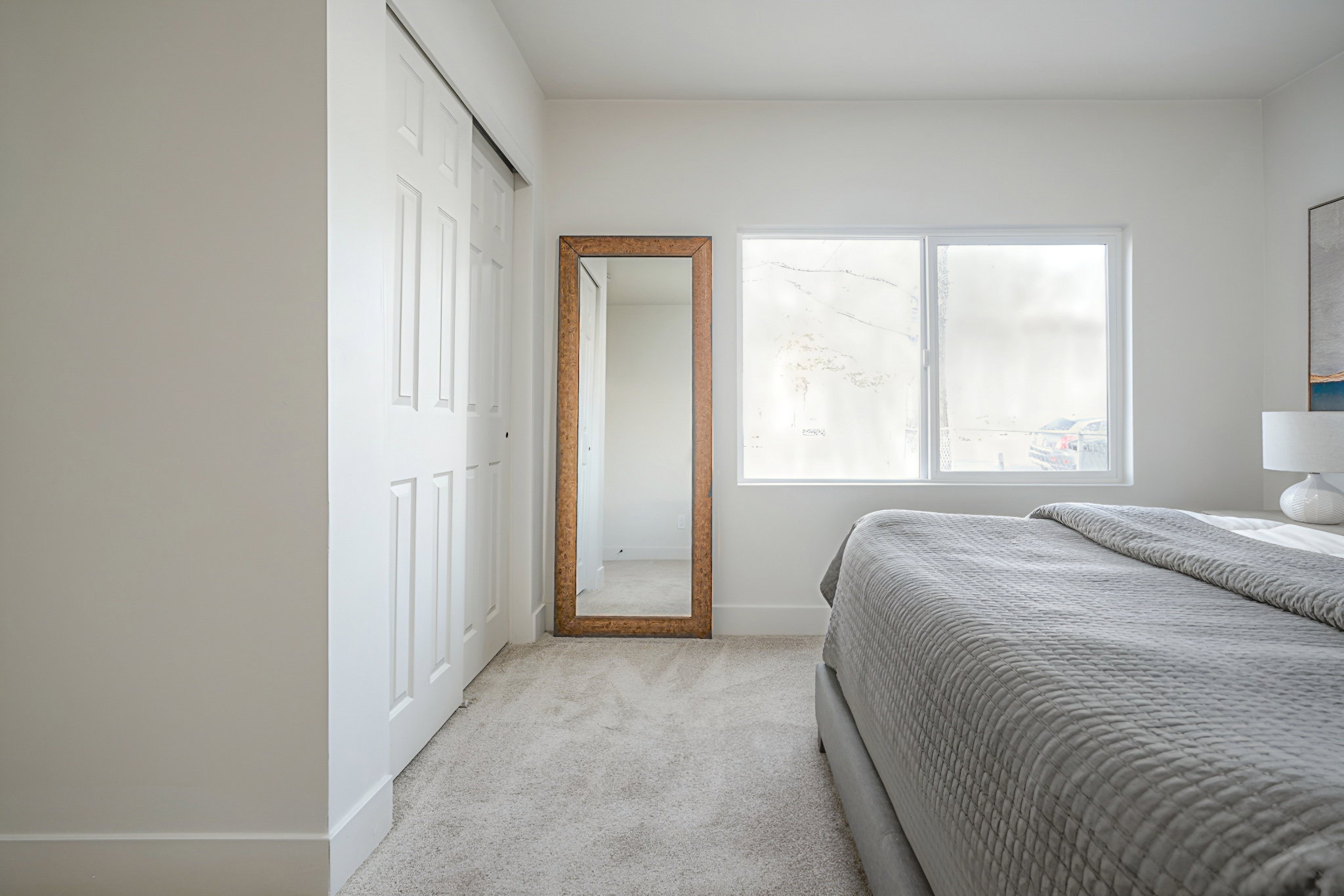 Bedroom with light colored carpet and a closet