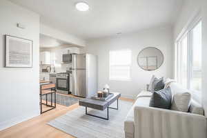 Living room featuring ornamental molding and light wood-type flooring