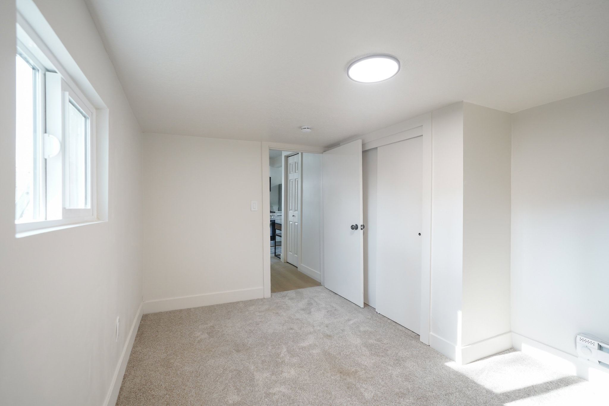 Unfurnished bedroom with light carpet and a closet