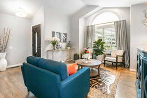 Living room with light wood-style flooring and vaulted ceiling