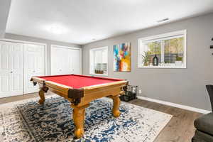 Playroom with wood finished floors and pool table