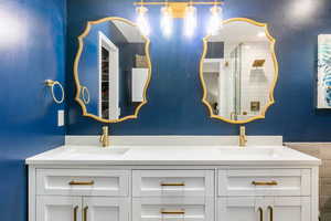 Full bath with a shower stall and double vanity