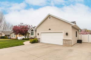 Single story home with stucco siding, a garage, and driveway