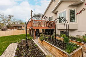 View of yard featuring a wooden deck and a vegetable garden